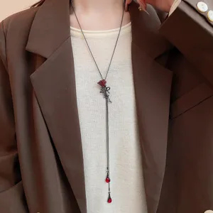 Primo piano dettagliato di una lunga collana a Y con elegante rosa rossa in stile chic.