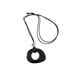 Elegante collana con ciondolo in resina nera in stile bohémien con forma geometrica e cordino.