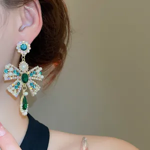 Détail de boucles d'oreilles pampilles strass style cour française, bijoux de luxe design niche.