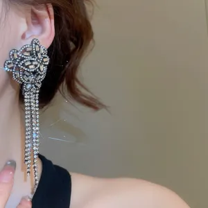 Gros plan détaillé de boucles d'oreilles longues et scintillantes en strass cristal.