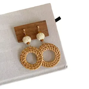 Zomerse vakantie rotan geweven oorbellen met houten kralen en geometrische cirkels stijlvol.