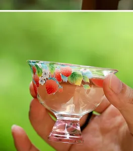 Close up of glass tea cup with hand painted strawberry pattern, delicate single master tea cup.