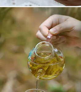 Kleine transparente Glasteekanne mit Blumenbemalung, fuer eine Person, hitzebestaendig.