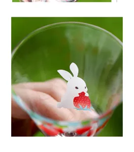 Close-up detail of clear glass tea cup featuring cute rabbit and strawberry print pattern.