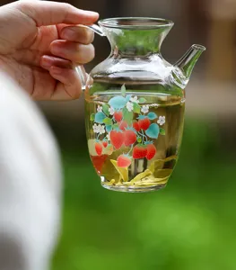 High borosilicate glass teapot detail view, heat resistant hand held pot with strawberry print.