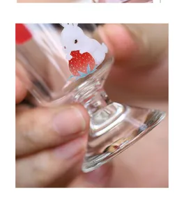 Primer plano detallado de la elegante taza de té de vidrio con un bonito diseño de fresa.