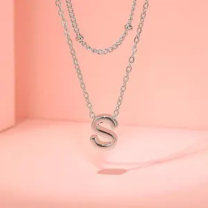 Collana doppia in argento con ciondolo lettera S e dettaglio catena di perline primo piano.