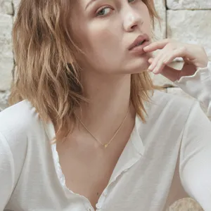 Délicat collier chaîne clavicule doré avec un pendentif lettre cœur minimaliste pour femmes.