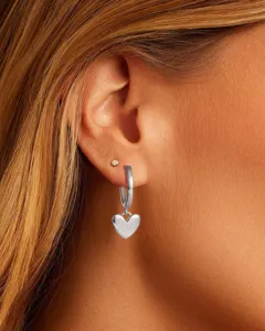 Dettaglio di orecchini a cerchio con pendente a cuore argento, stile minimalista ed elegante.