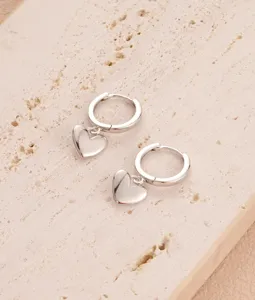 Orecchini a cerchio con ciondolo a cuore argentato, elegante gioiello di moda minimalista.