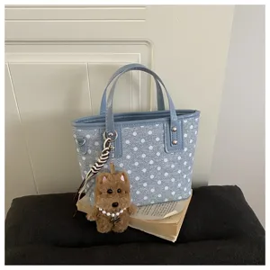 Detailansicht einer blauen gepunkteten Eimertasche mit süßem braunen Plüschhund Anhänger.
