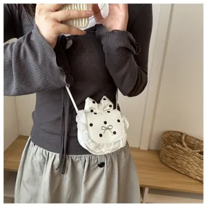 Close-up detail of the cute white mini cross-body bag featuring black polka dots and lace trim.