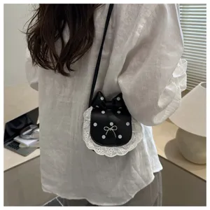 Detail view of the cute mini polka dot crossbody bag with delicate lace trim and bow.