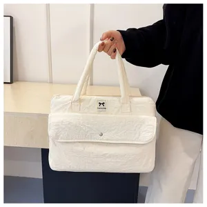 Detailansicht der weißen gesteppten Laptoptasche mit Fronttasche und praktischen Tragegriffen.