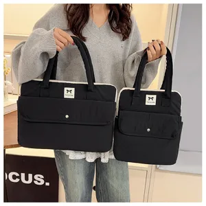 Detailansicht der schwarzen gepolsterten Laptoptasche mit zwei Griffen und Vordertasche.