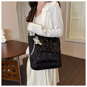 Black star print tote bag detail showing exterior pocket and starfish charm decor.