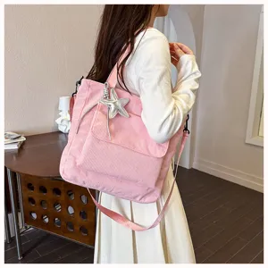 Pink corduroy tote bag detail showing the soft fabric texture and silver star charm pendant.
