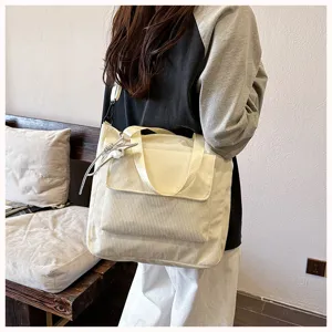 Corduroy tote bag detailed view, white casual shoulder bag with pocket, daily fashion style.