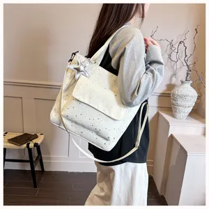 Detail view of a stylish large-capacity white tote bag with star print and silver star pendant.