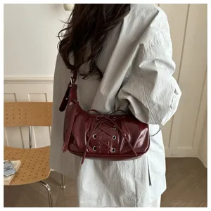 Sac à épaule tendance en cuir verni rouge vin avec laçage pour femme, élégant au quotidien.