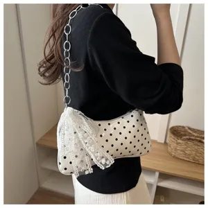 Gedetailleerd overzicht van witte polkadot okseltas met kantstrik en ketting.