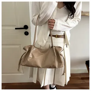 Glossy khaki leather shoulder bag detail, stylish hobo baguette bag with drawstrings.