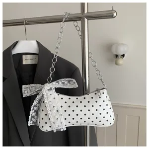 Wit polkadot okseltas detail met chique kanten strik en elegante metalen kettingriem voor dames.