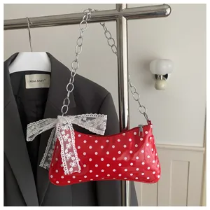 Rode schoudertas met polstippen voor dames, chique okseltas met ketting en kanten strik.
