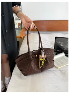 Dettaglio borsa marrone in camoscio maculato, grande borsa a spalla con grazioso ciondolo orsetto.