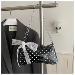 Zwarte en witte polkadot lakleer schoudertas met schattige kanten strik en metalen ketting.