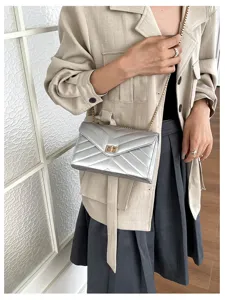 Metallische silberne Schultertasche mit Steppung und Kettengurt für modebewusste Damen.
