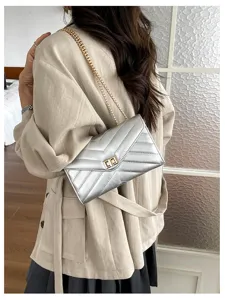 Detailaufnahme der stilvollen silbernen Umhängetasche mit Steppung und Kette.