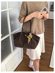 Dettaglio borsa shopper in camoscio leopardato rétro, elegante e capiente borsa a spalla per il lavoro.