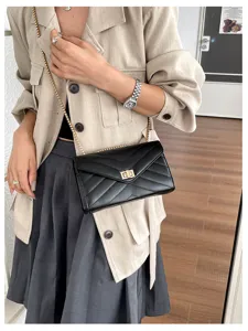 Schwarze gesteppte Umschlag-Umhängetasche mit goldener Kette für stilvolle Damen.