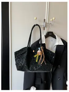 Vista dettagliata della grande borsa tote a spalla in camoscio con stampa leopardo nero.