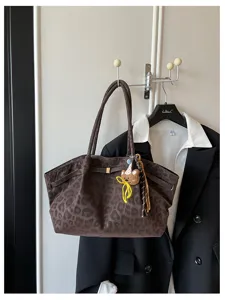 Dettaglio borsa shopper in camoscio leopardato marrone, elegante borsa spalla per lavoro.