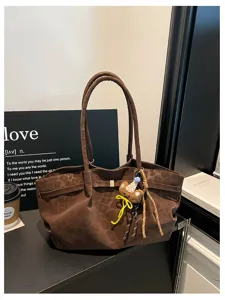 Dettaglio borsa marrone in camoscio, grande borsa a spalla retrò con grazioso ciondolo orsetto.