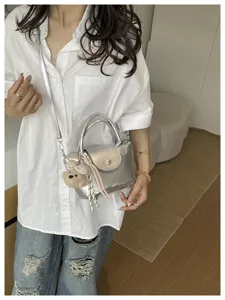 Stijlvolle zilveren metallische schoudertas met schattige pluche berenhanger accessoire