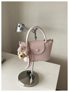Roze lederen emmertas met schattige puppy hanger, stijlvolle schouder- en handtas.