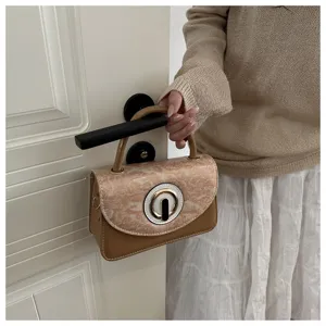 Detailed view of stylish mini square crossbody bag for girls, trendy design with metal clasp.
