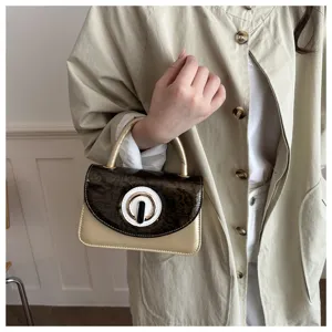 Vista de cerca de un bolso de mujer elegante con solapa texturizada y cierre único.