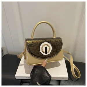 Chic patent leather shoulder bag with gold handle and unique round buckle for daily commute.