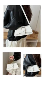 Detailed view of white leather shoulder bag with metal chain strap and retro buckle design.