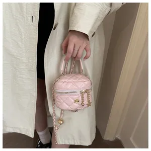 Mini bolso cruzado acolchado rosa con correa de cadena y detalle de dije de flor.