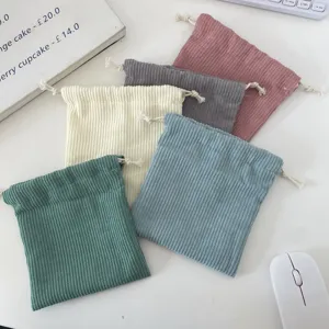 Detailed view of colorful corduroy drawstring storage pouches with soft ribbed texture