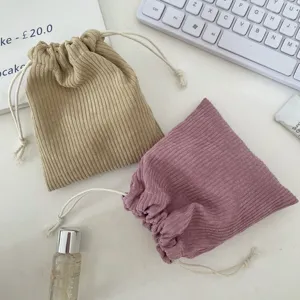 Two corduroy drawstring cosmetic pouches highlighting fabric texture and design details