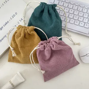 Three-piece corduroy drawstring cosmetic bags in assorted muted tones.