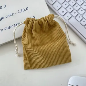 Close-up of yellow corduroy drawstring pouch showing fine vertical ribbed texture