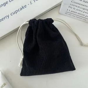Close-up of black corduroy drawstring pouch with white ropes