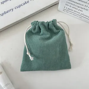 Close-up of green corduroy drawstring storage bag showing soft ribbed texture